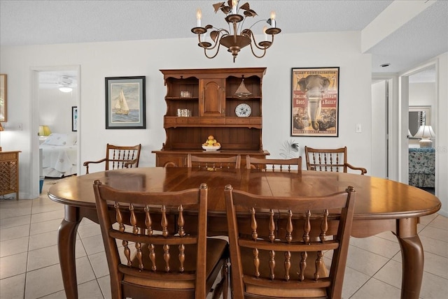 dining space with a textured ceiling, light tile patterned flooring, and a notable chandelier