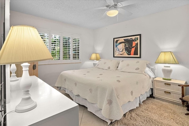 bedroom with ceiling fan and a textured ceiling