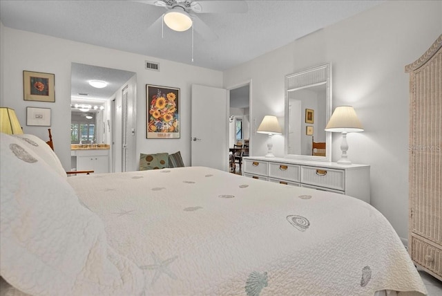bedroom with ceiling fan, ensuite bath, and visible vents