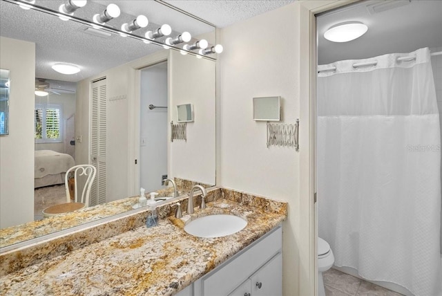 bathroom featuring toilet, vanity, a ceiling fan, and a textured ceiling