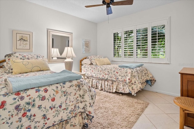 bedroom featuring tile patterned floors, a textured ceiling, baseboards, and a ceiling fan