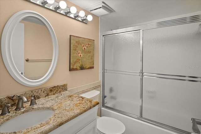 full bathroom featuring vanity, toilet, visible vents, and enclosed tub / shower combo