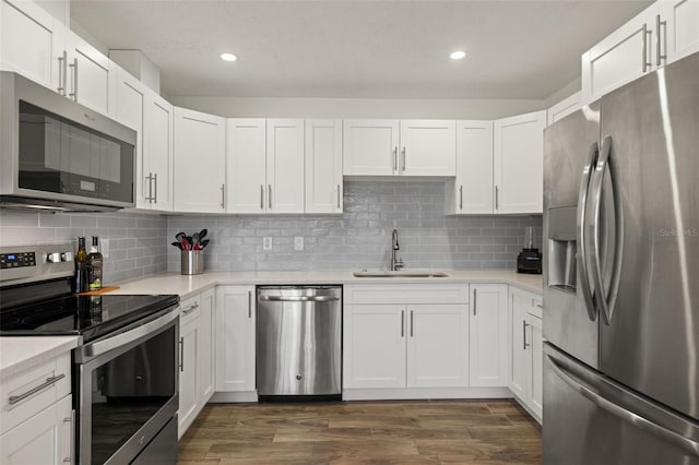 1458 Alwynne Dr N, Lehigh Acres, FL 33936 - kitchen with white cabinets, a sink, light countertops, stainless steel appliances, and recessed lighting
