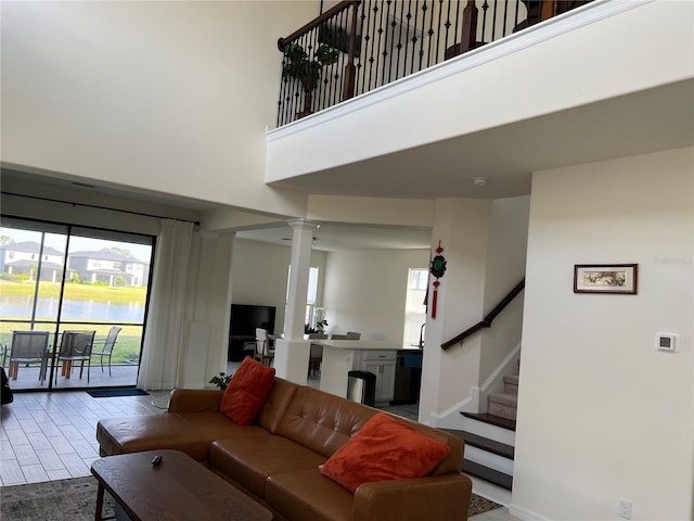 5521 Summit Gln, Bradenton, FL 34203 - living room with ornate columns, healthy amount of natural light, stairway, a towering ceiling, and baseboards