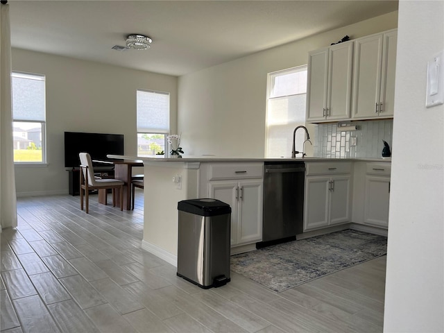 5521 Summit Gln, Bradenton, FL 34203 - kitchen featuring dishwasher, a peninsula, plenty of natural light, and tasteful backsplash