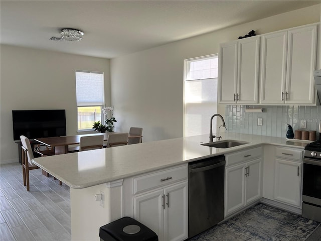 5521 Summit Gln, Bradenton, FL 34203 - kitchen with dishwashing machine, a sink, a peninsula, stainless steel gas range oven, and plenty of natural light