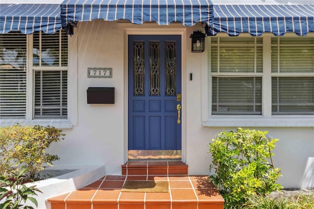 entrance to property featuring metal roof and stucco siding