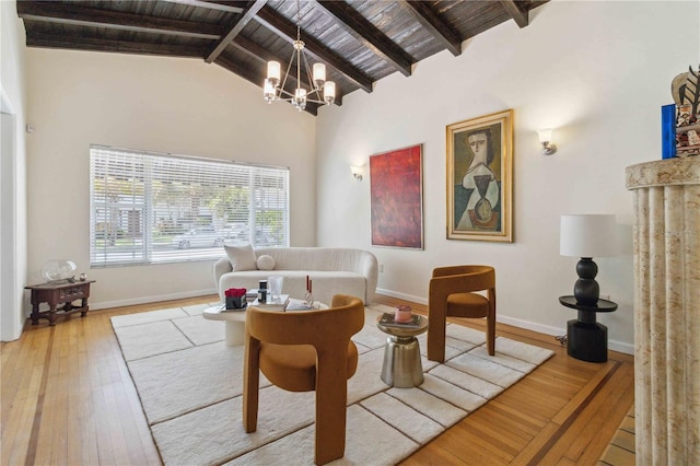 living area featuring beam ceiling, hardwood / wood-style floors, baseboards, wood ceiling, and a chandelier