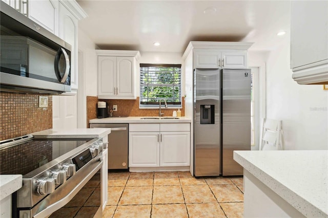kitchen featuring light countertops, stainless steel appliances, white cabinets, and a sink
