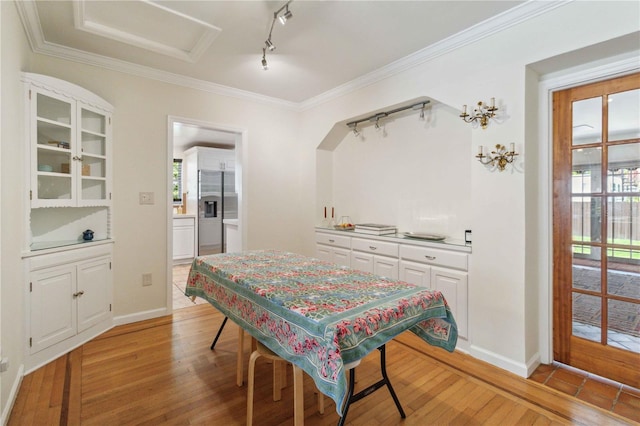 dining area featuring track lighting, light wood-type flooring, and a wealth of natural light