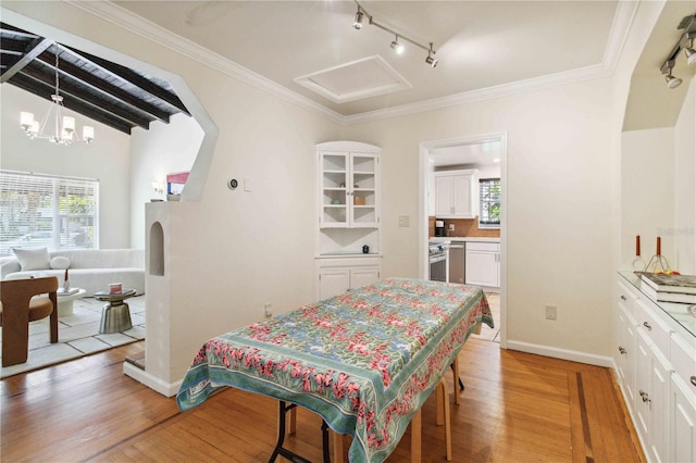 bedroom featuring crown molding, track lighting, and light wood-style floors