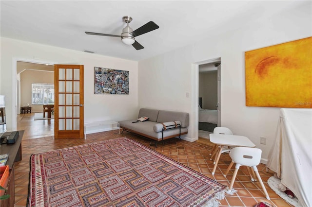 living area featuring baseboards, ceiling fan, french doors, and visible vents