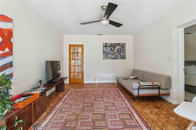 living room with tile patterned floors, baseboards, and a ceiling fan