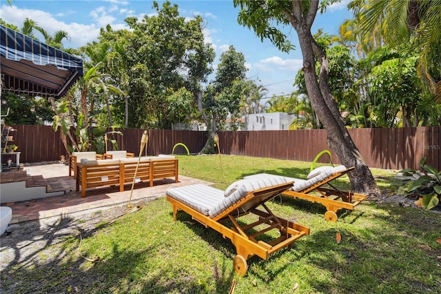 view of yard with a patio, an outdoor living space, and a fenced backyard