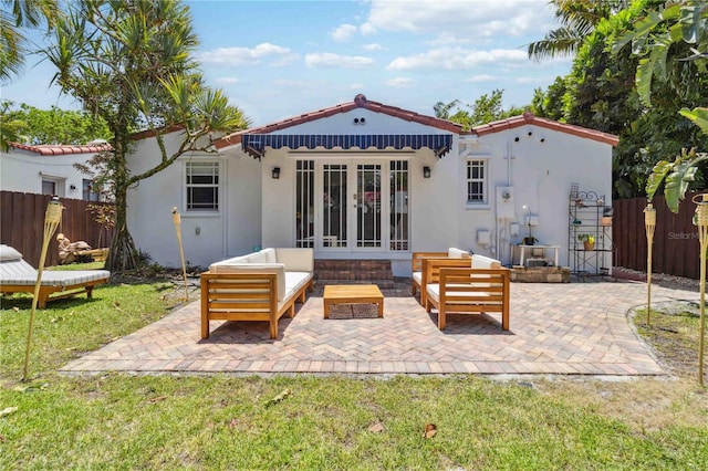back of property with fence, stucco siding, and a patio area