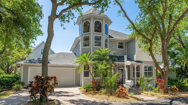 view of front of home featuring an attached garage, a shingled roof, and driveway