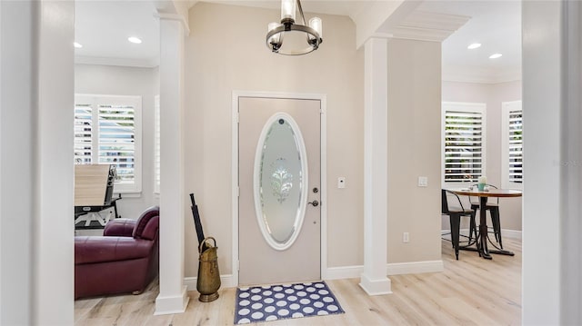 foyer entrance featuring ornamental molding, plenty of natural light, and wood finished floors