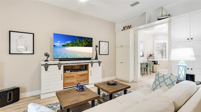 living room with baseboards, light wood-style flooring, visible vents, and a ceiling fan