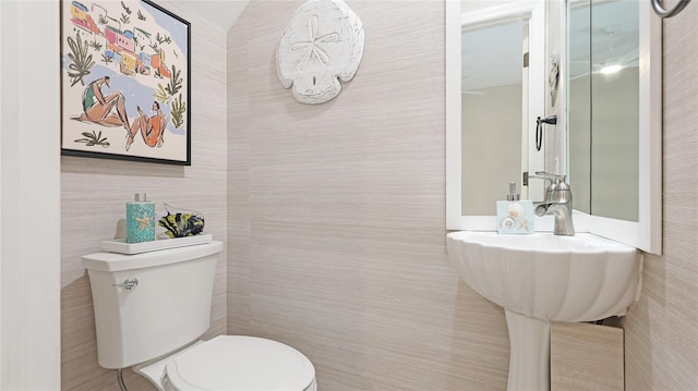 bathroom featuring toilet and tile walls