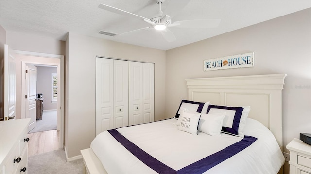 bedroom with a ceiling fan, a closet, baseboards, visible vents, and light carpet