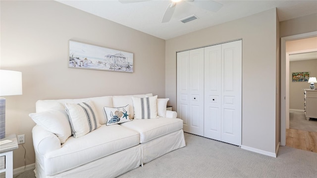 living area with baseboards, carpet floors, visible vents, and a ceiling fan