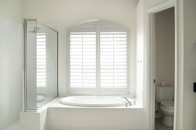 full bathroom with a stall shower, toilet, and a garden tub