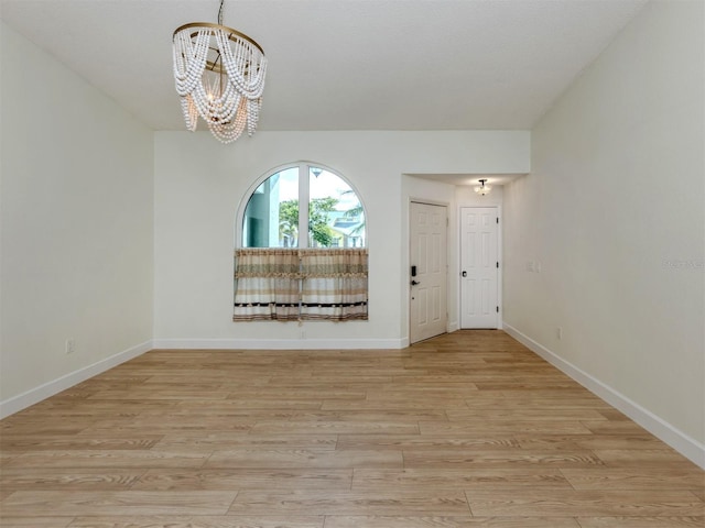 245 Woodingham Trl, Venice, FL 34292 - spare room with a chandelier, baseboards, and light wood-style floors