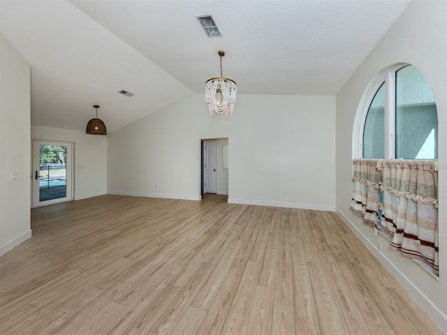245 Woodingham Trl, Venice, FL 34292 - spare room with a chandelier, light wood-style floors, lofted ceiling, and baseboards
