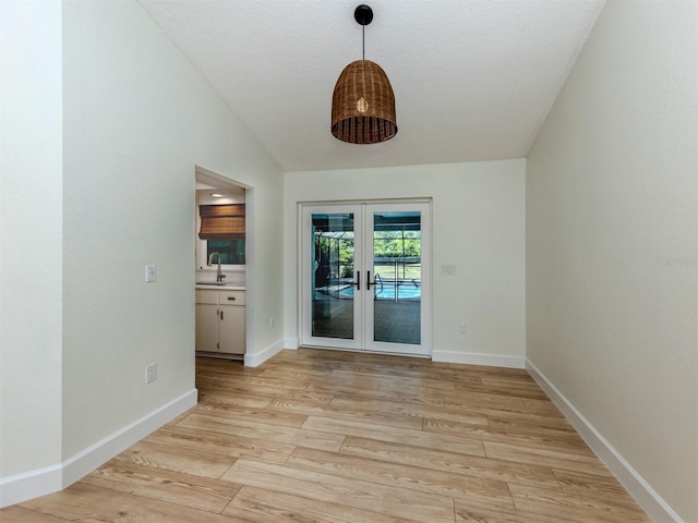 245 Woodingham Trl, Venice, FL 34292 - empty room with a sink, light wood finished floors, french doors, baseboards, and a textured ceiling