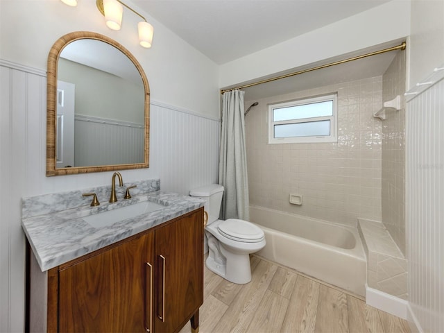245 Woodingham Trl, Venice, FL 34292 - bathroom with wood finished floors, shower / bath combo with shower curtain, toilet, vanity, and wainscoting