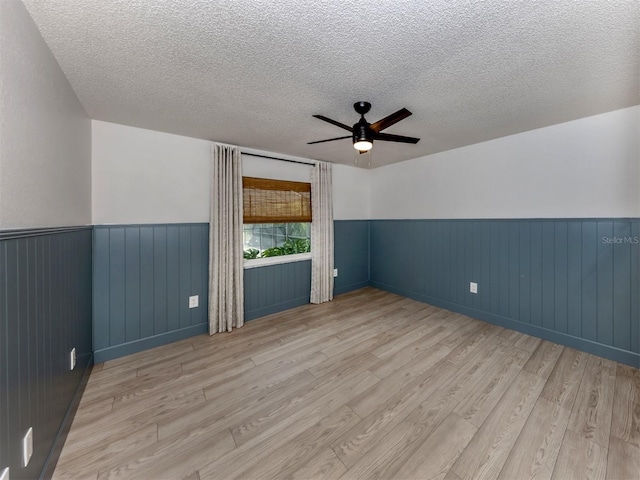 245 Woodingham Trl, Venice, FL 34292 - spare room with wainscoting, wood finished floors, a textured ceiling, and ceiling fan