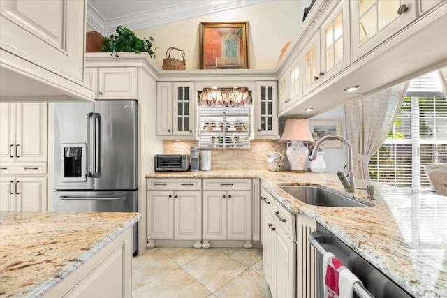 kitchen featuring crown molding, stainless steel appliances, a sink, and backsplash