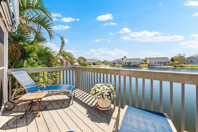 wooden terrace with a water view and a residential view