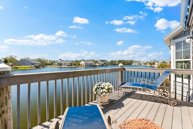 wooden terrace with a water view and a residential view