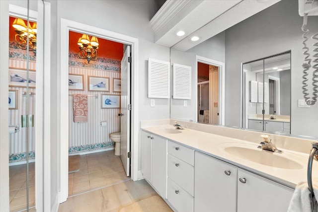 full bath with double vanity, toilet, baseboards, and a sink