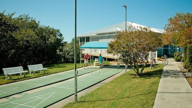 view of home's community featuring a yard and shuffleboard
