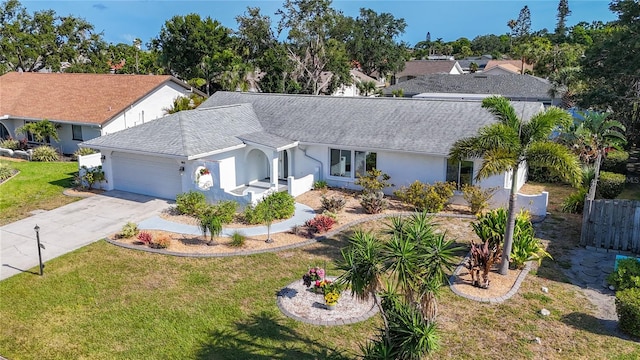 6012 11th Ave W, Bradenton, FL 34209 - ranch-style house with roof with shingles, concrete driveway, a garage, stucco siding, and a front yard