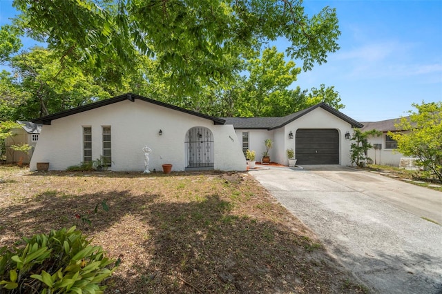 ranch-style home with an attached garage, stucco siding, and driveway