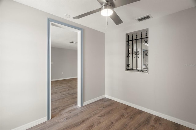 unfurnished room featuring ceiling fan, baseboards, visible vents, and wood finished floors