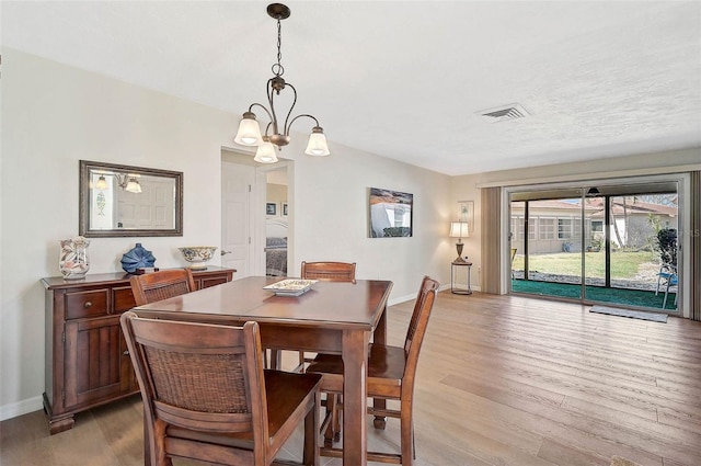 151 Vista Hermosa Cir Unit 31C, Sarasota, FL 34242 - dining room with light wood finished floors, baseboards, and a chandelier