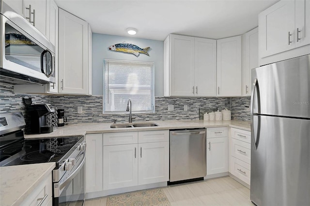 151 Vista Hermosa Cir Unit 31C, Sarasota, FL 34242 - kitchen with appliances with stainless steel finishes, a sink, backsplash, and white cabinets