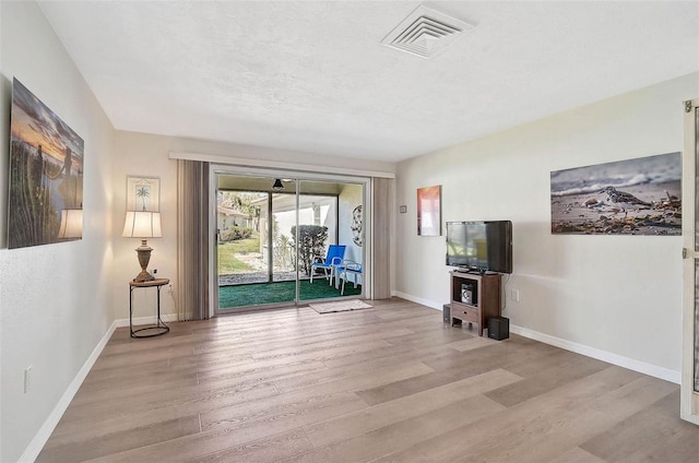 151 Vista Hermosa Cir Unit 31C, Sarasota, FL 34242 - unfurnished living room featuring wood finished floors, baseboards, and a textured ceiling
