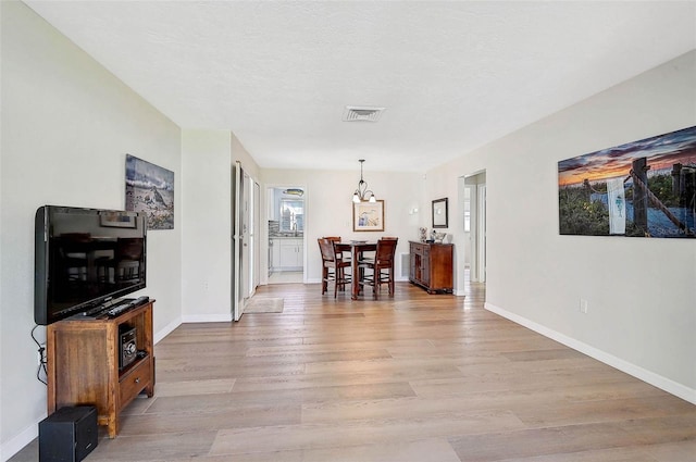 151 Vista Hermosa Cir Unit 31C, Sarasota, FL 34242 - hallway with light wood-type flooring, baseboards, and a chandelier