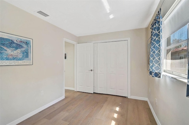 151 Vista Hermosa Cir Unit 31C, Sarasota, FL 34242 - unfurnished bedroom featuring wood finished floors, baseboards, and a closet