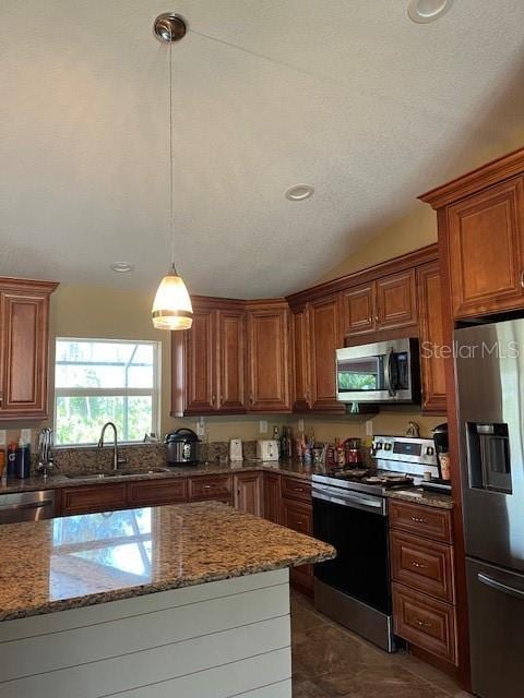 7286 Mineola Rd, Englewood, FL 34224 - kitchen featuring stainless steel appliances, a sink, stone countertops, lofted ceiling, and hanging light fixtures