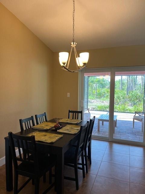 7286 Mineola Rd, Englewood, FL 34224 - dining space with a chandelier, light tile patterned floors, and baseboards