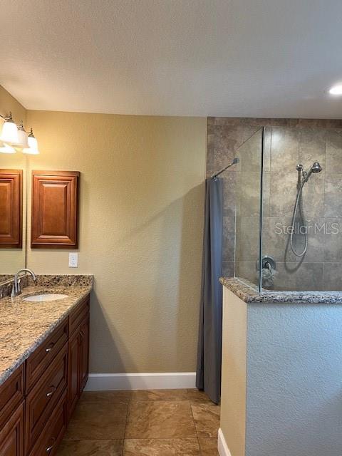 7286 Mineola Rd, Englewood, FL 34224 - full bathroom featuring walk in shower, baseboards, and vanity