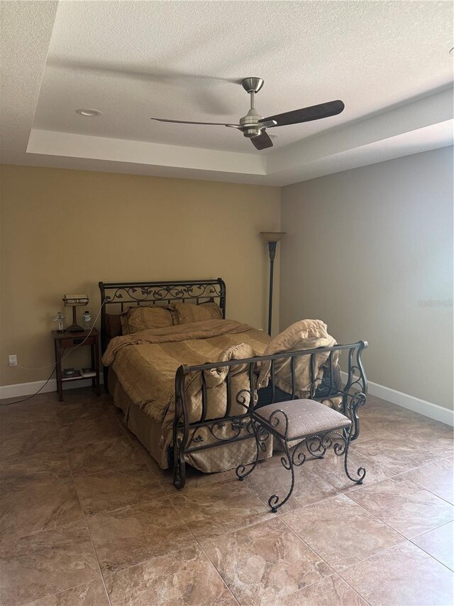 7286 Mineola Rd, Englewood, FL 34224 - bedroom featuring a tray ceiling, a ceiling fan, baseboards, and a textured ceiling