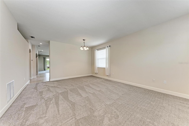 empty room with a chandelier, baseboards, light colored carpet, and recessed lighting