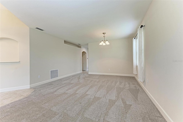 unfurnished room with arched walkways, a chandelier, carpet floors, and baseboards
